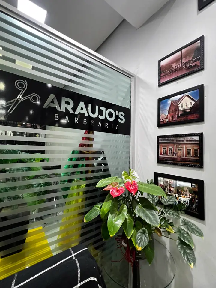 Entrada da Araujo's Barbearia com o logo no vidro