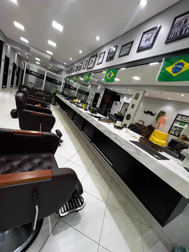 Bancada com cadeiras de barbeiro e quadros na parede