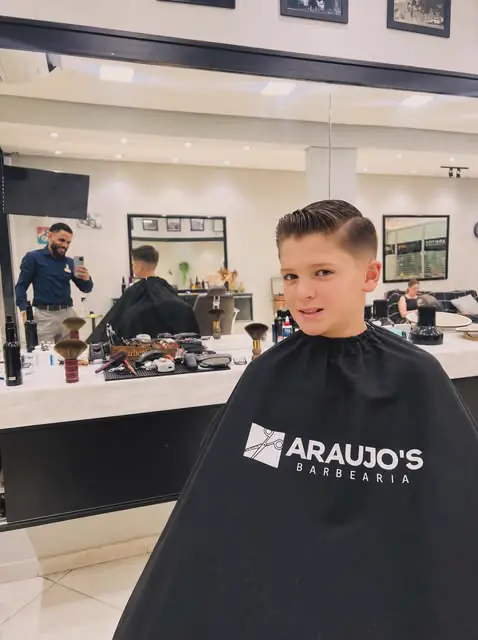 Cliente jovem com capa da Araujo's Barbearia